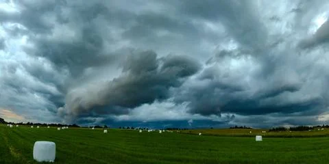 Storm clouds over field, tornadic supercell, extreme weather, dangerous storm Foto stock