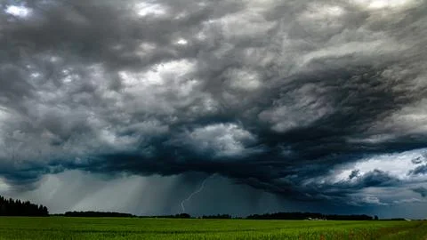 Storm clouds over field, tornadic supercell, extreme weather, dangerous storm Stock Photos