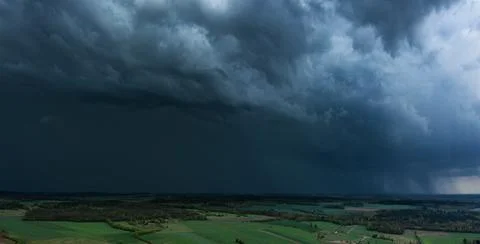 Storm clouds over field, tornadic supercell, extreme weather, dangerous storm Stock Photos
