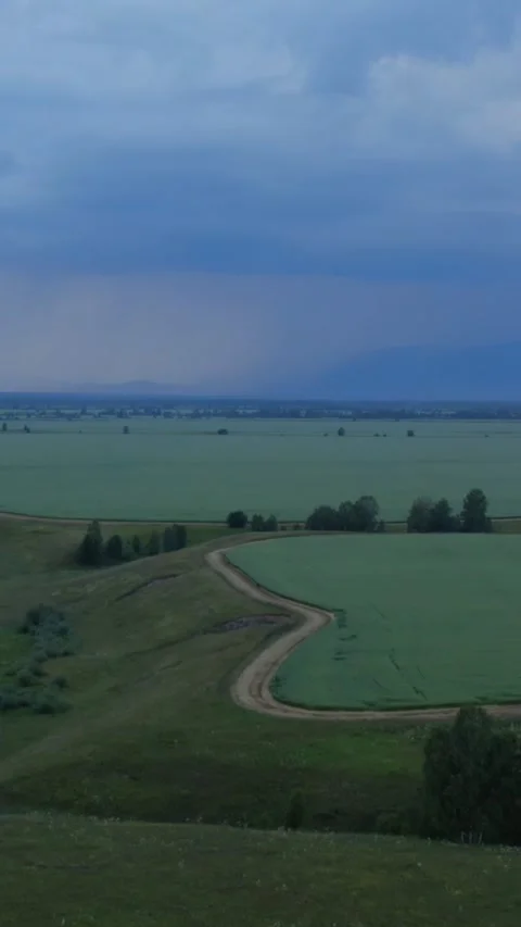 Storm clouds over green fields near Zamul'ta village, Altai landscape footage Stock Footage 335660891