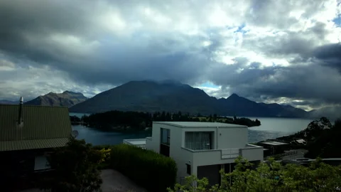 Storm clouds over lake and mountains viewed from residential area Stock Footage 325695613