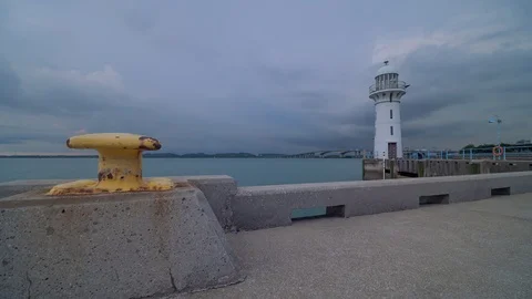 Storm clouds over lighthouse moving from Singapore to Malaysia during sunset Stock Footage 108085837