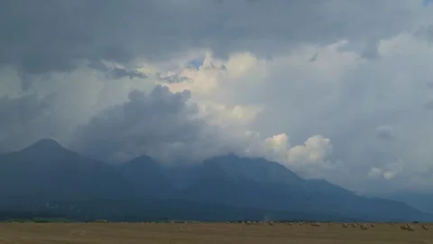 Storm Clouds Over Mountains and Harvest Field Stock-Footage 330788457