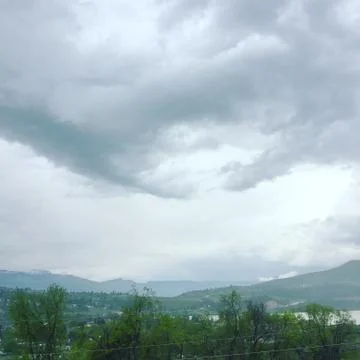 Storm clouds over mountains and lake Stock Photos