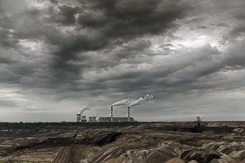 Storm clouds over open pit mine and power plant. Stock Photos