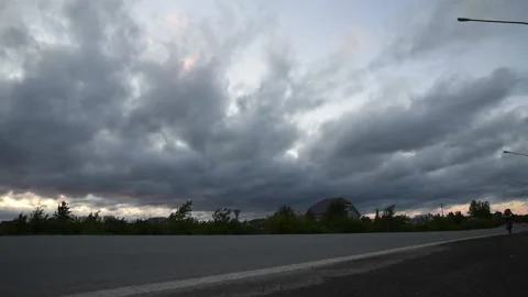 Storm clouds over road after rain in the evening traffic movement on the road Stock Footage 139477979