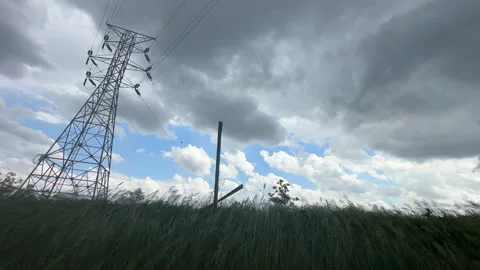 Storm clouds over a rural field with transmission tower Video stock 343561365