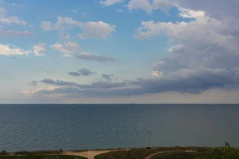 Storm clouds over the sea and the city. Stock Photos