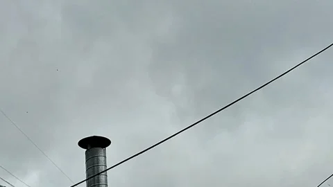 Storm Clouds Over Urban Rooftop Chimney and Power Lines in Sky Stock Footage 337450298