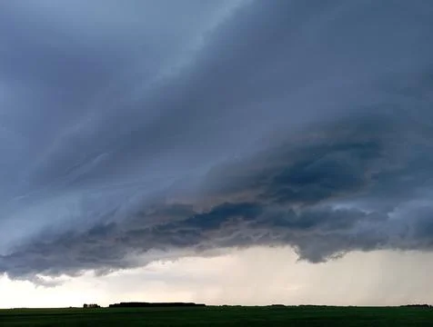 Storm clouds over a wheat field, a tornado is visible in the distance. Foto stock