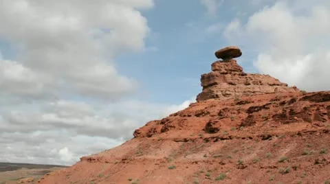 Storm clouds pass over a small rock tower in Mexican Hat Canyon. Video stock 11518987