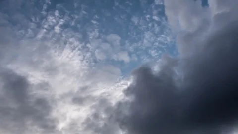 Storm clouds passing at speed on a blue sky lit by bright sunshine Stock Footage 78219089