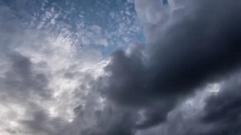 Storm clouds passing at speed on a blue sky lit by bright sunshine Stock-Footage 78219094