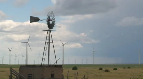 Storm clouds produce wind for irrigation windmill and wind turbines Stock Footage 40266076
