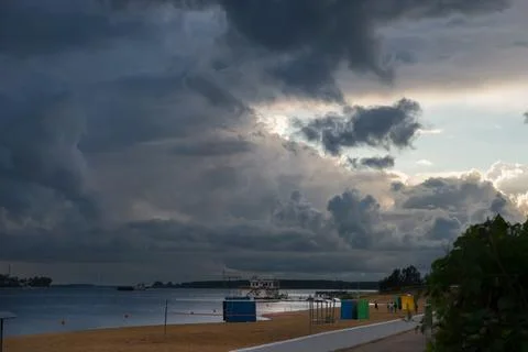 Storm clouds with rain closer to the river beach Stock Photos