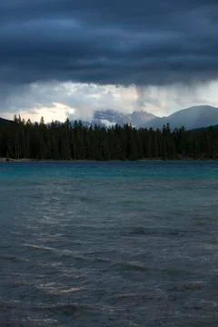 Storm clouds raining over lake Stock Photos