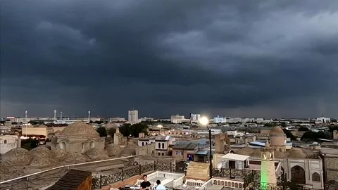 Storm clouds rolling over the ancient cityscape of Bukhara at dusk Stock Footage 335834898