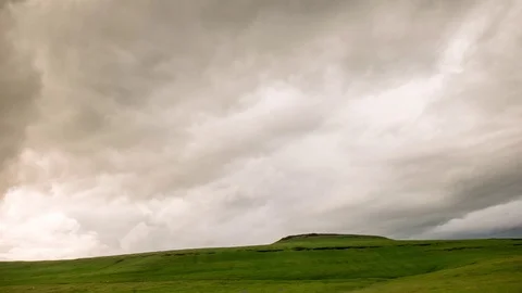 Storm Clouds Rolling Over A Green Grass Covered Hill Stock Footage 106157232