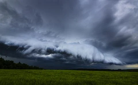 Storm clouds, shelf cloud over field, extreme weather, dangerous storm Stock Photos