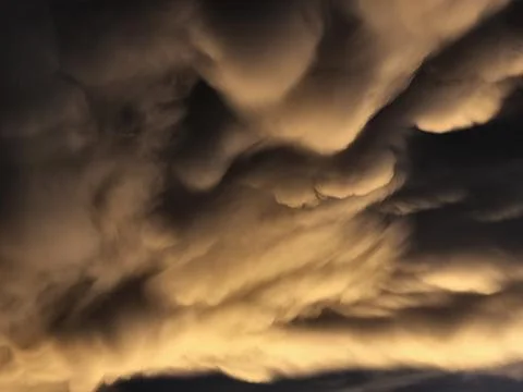 Storm clouds on sunset. Light in the dark and dramatic storm clouds. Background Stock Photos