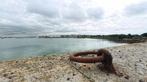 Storm clouds time lapse rolling across Holyhead harbour seafront beside rusted Stock Footage 314587166