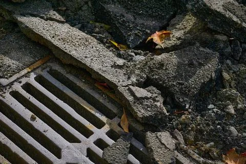 Storm drain grate before removal during road repairs Stock Photos