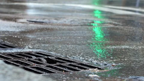 Storm drain grate on the road during a rainstorm. Vídeos de archivo 271669543