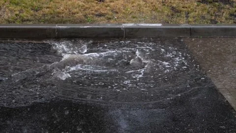 The storm drain on the road cannot cope with the flow of rainwater. Stock Footage 199764839