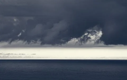 Storm dramatic clouds over the surface of the sea 库存照片