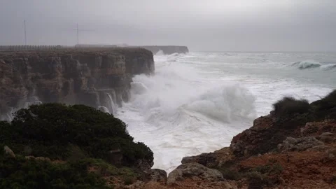 Storm-driven big waves crash against the cliffs of Sagres Stock Footage 327837901