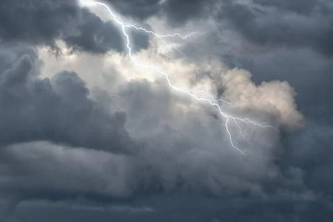Storm lightning strike in dark ominous clouds overhead Stock Photos