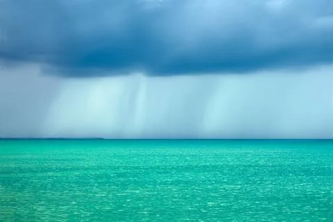 Storm rain clouds over the turquoise sea Stock Photos