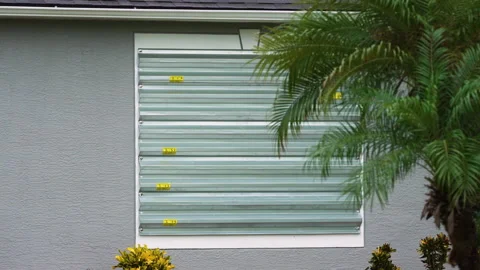 Storm resistant steel shutters cover windows of Florida house as precaution Stock Footage 325404853