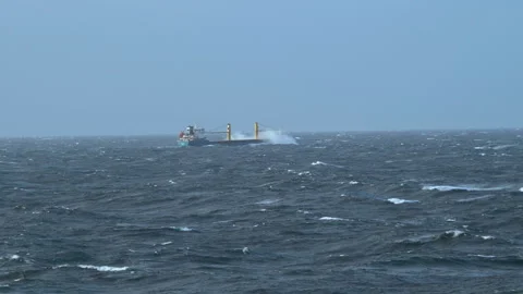 Storm. Sea. Ship breaks a wave. Splashes of water fill bow of cargo vessel 스톡 동영상 243393744