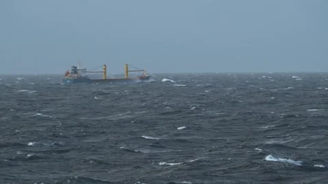 Storm at sea. Ship breaks a wave. Splashes of water fill bow of cargo vessel Stock Footage 266243402