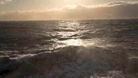 Storm at sea. Splashes from waves in gusts of wind low over water in rays of sun Stock Footage 262053993