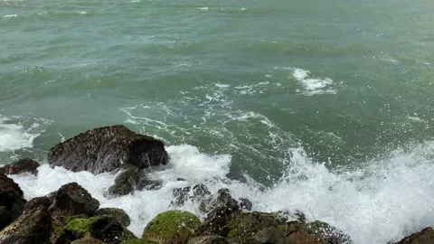 Storm on the sea, Turquoise rolling wave slamming on the rocks of the coastline Stock Footage 164871817