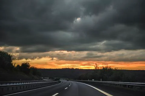 Storm sunset on the highway Stock Photos