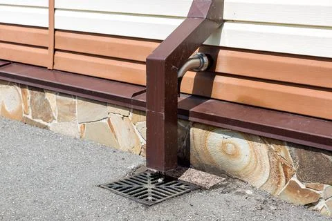 Storm system rainwater drain pipe from the roof of the building. Stock Photos