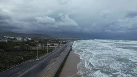 Storm waves hitting a beach promenade, aerial view, Crete Stock Footage 346723744