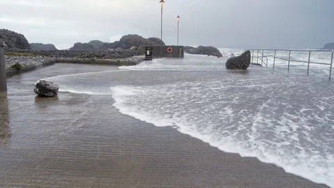 Storm Waves wash over Jetty Ballintoy Harbour Causeway Coast Northern Ireland Stock Footage 99014393