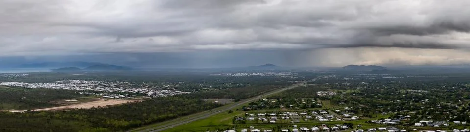 Storms over a mountain range and city in the distance, Townsville Stock Photos