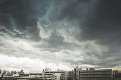 Storms, rain clouds are forming on big cities. Stock Photos