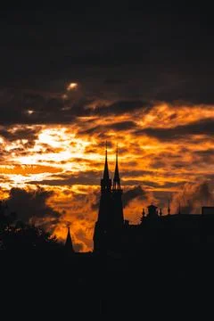 Stormy and dramatic sunset and silhouettes of the cathedral spire in Amsterda Stock Photos