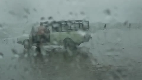 Stormy beach with man changing clothes near truck through rainy glass Stock Footage 318685918