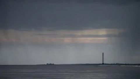 Stormy clouds mover over water with lighthouse Stock Footage 79251411