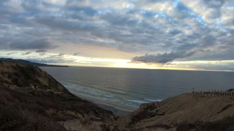 As stormy clouds roll by, a paraglider flies into view over a dark, gloomy beach 库存影片 82098138