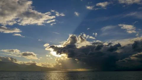Stormy clouds with sun shining. Dramatic thunderstorm cloudscape. Stock Photos