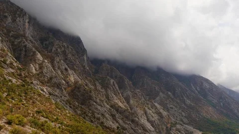 Stormy clouds on the top of rocky mountain ridge at the shore of sea bay in 스톡 동영상 83122850