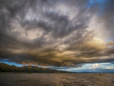 Stormy, cloudy sunset over Inle Lake in Myanmar, dramatic sky with dark rain Stock Photos
